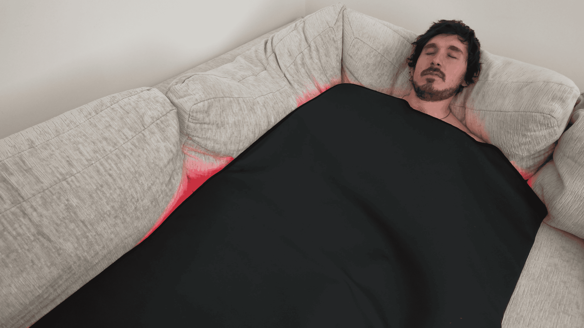 Relaxing effortlessly inside the red light blanket on the living room sofa