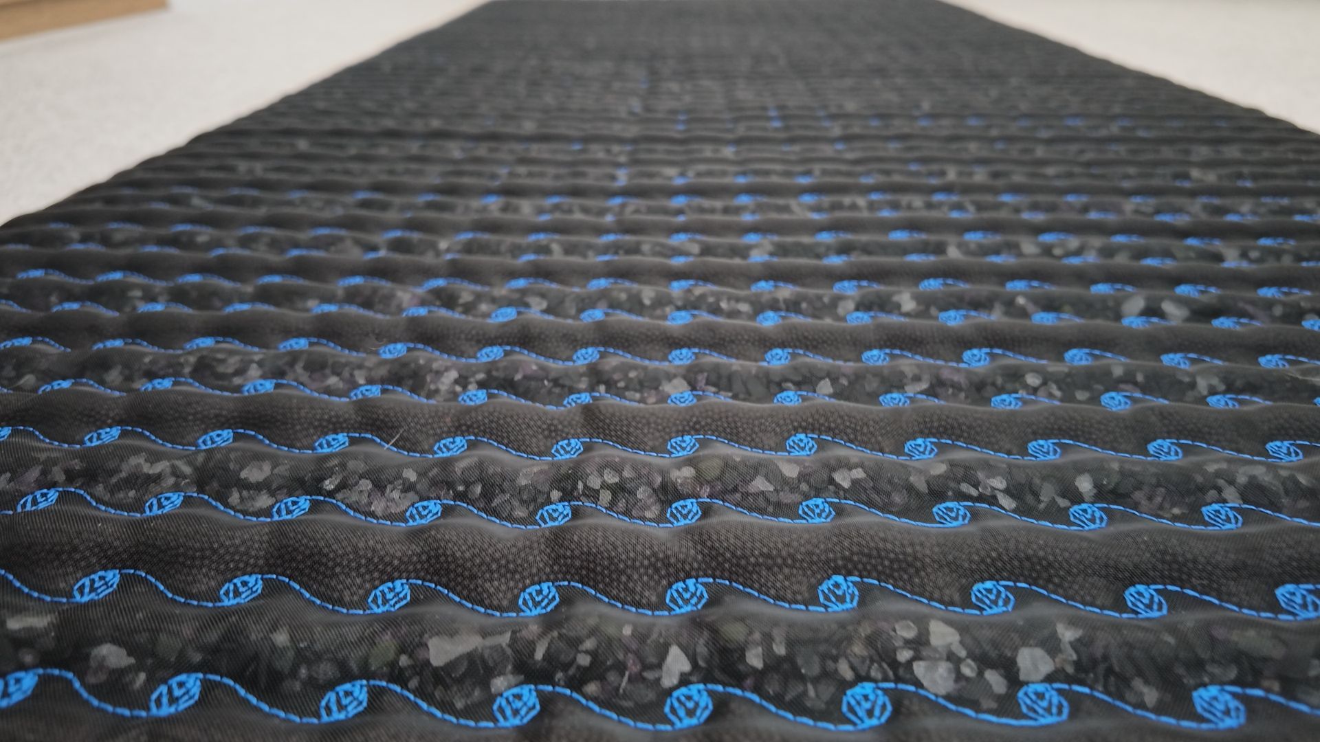 PEMF mat laid flat on the floor showing its thick, rigid multi-layer construction
