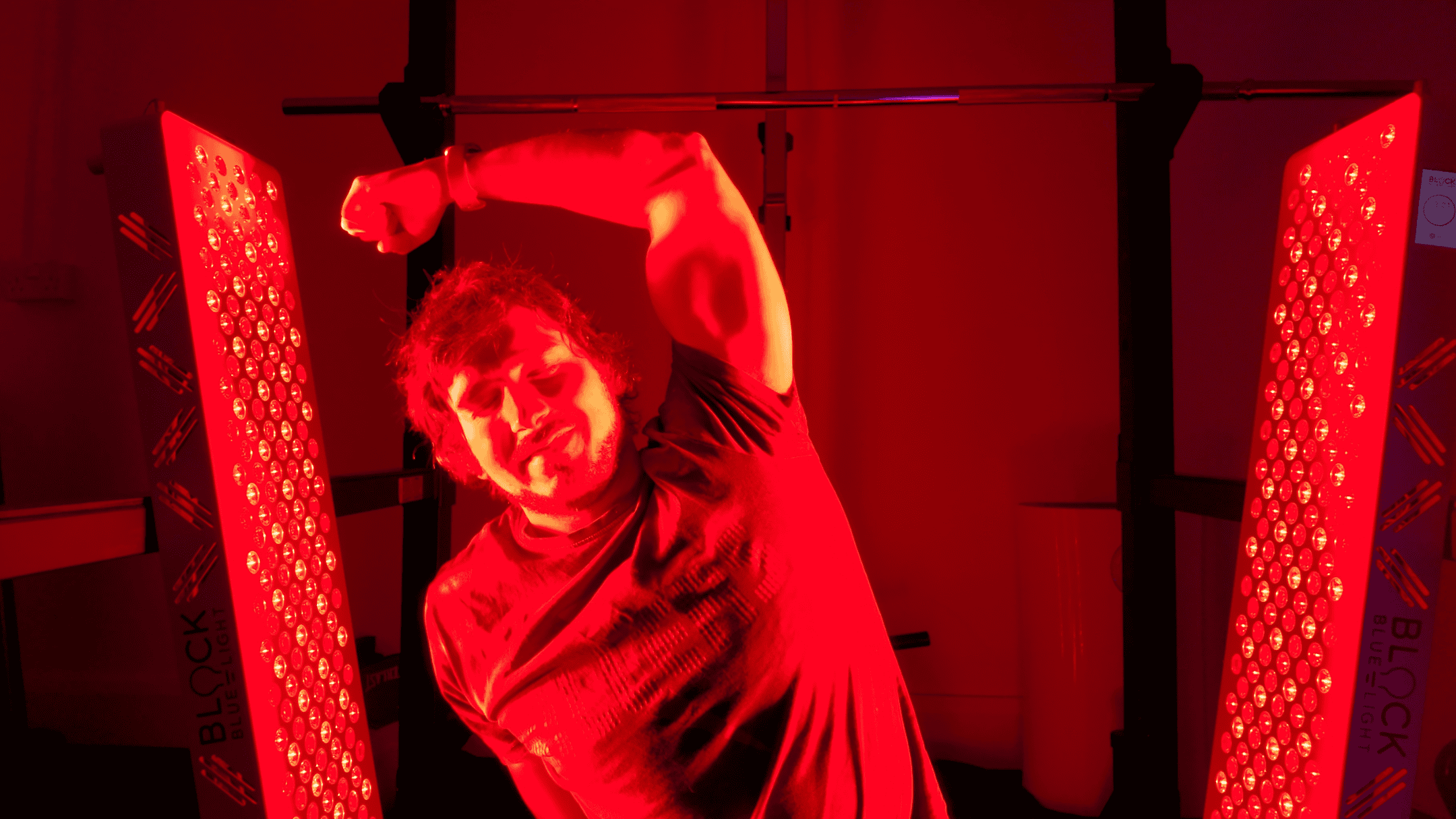 garage biohacker in between two red light panels in his garage
