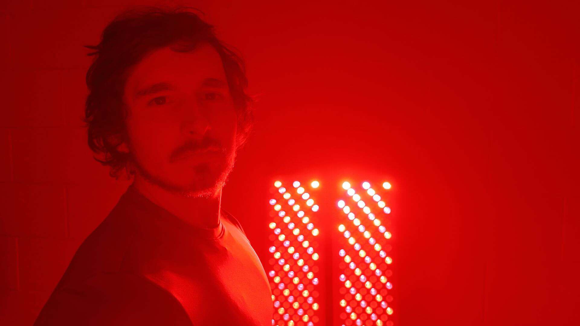 Full facial and scalp red light immersion in front of dual LED panels